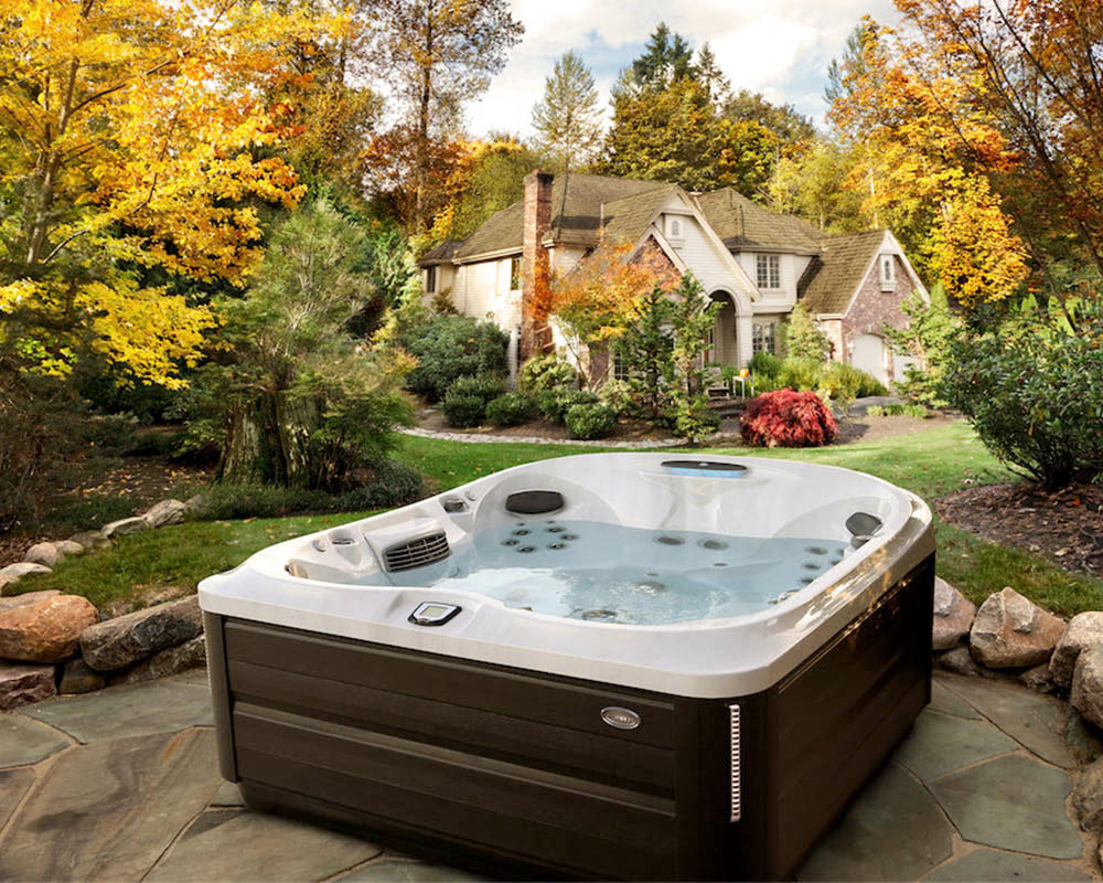 Jacuzzi 485 hot tub installed in the backyard surrounded by autumn foliage and a wooden deck