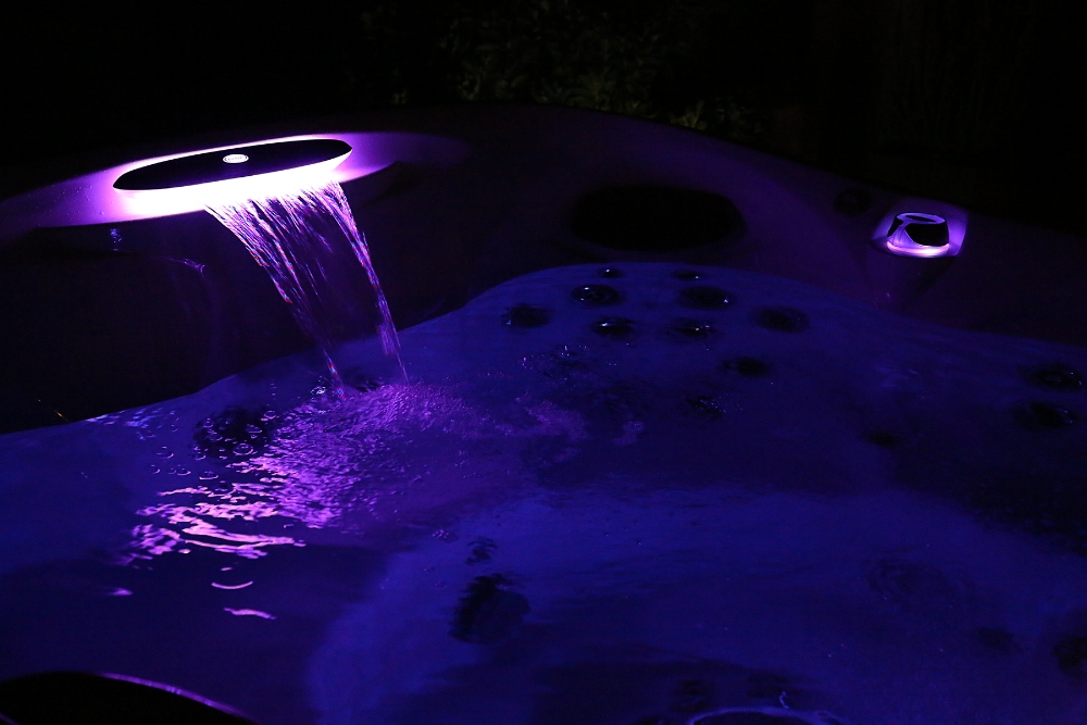 Jacuzzi® hot tub glowing purple at night - WCI Pools & Spas explains the 5 benefits of chromotherapy.